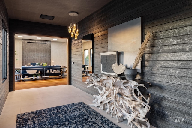 bathroom with tile patterned floors and wooden walls