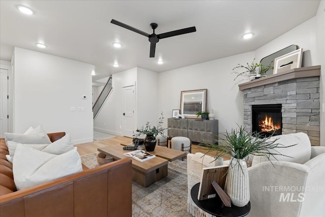 living room with ceiling fan, light hardwood / wood-style floors, and a fireplace