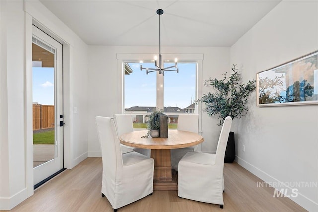 dining area featuring light hardwood / wood-style floors and a notable chandelier