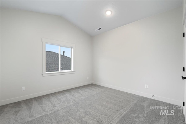 empty room featuring lofted ceiling and carpet floors