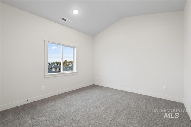 carpeted spare room with lofted ceiling