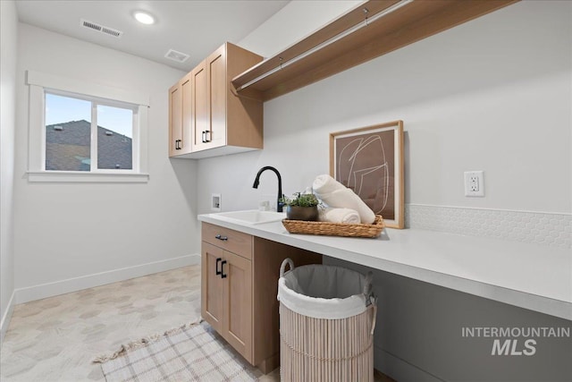 clothes washing area featuring cabinets, hookup for a washing machine, and sink