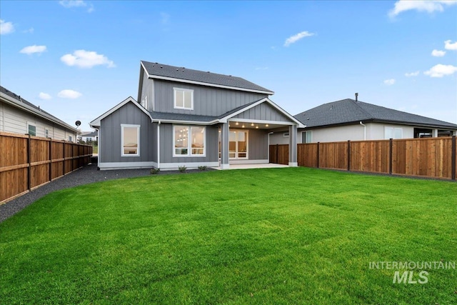 rear view of property with a lawn