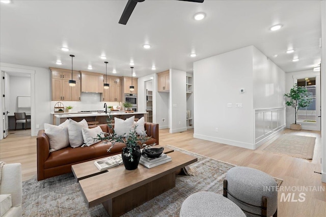 living room with ceiling fan and light wood-type flooring