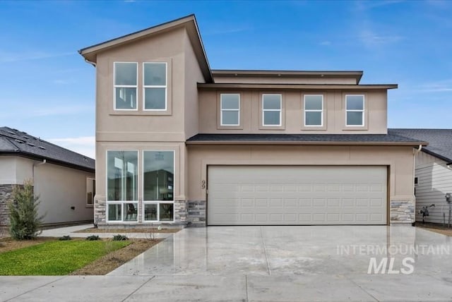 view of front facade with stone siding, an attached garage, and driveway