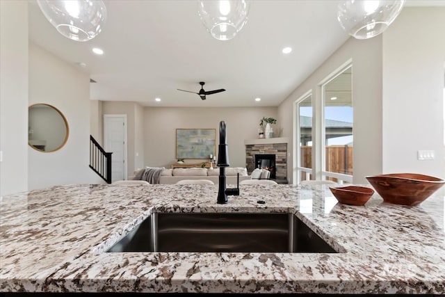 kitchen featuring a sink, light stone countertops, ceiling fan, and recessed lighting