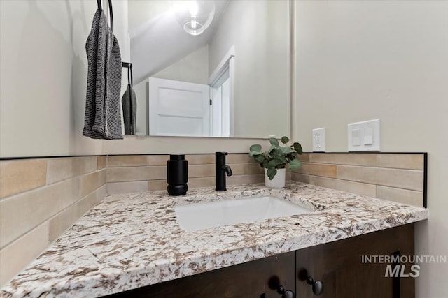 bathroom featuring vanity and tasteful backsplash