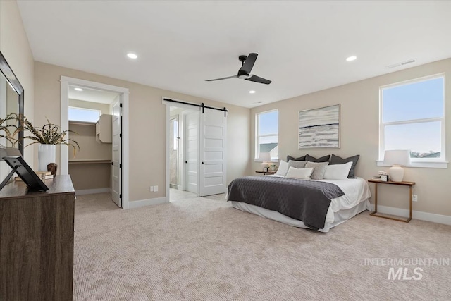 bedroom with visible vents, baseboards, light colored carpet, a barn door, and recessed lighting