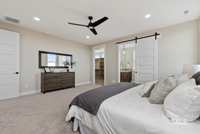 carpeted bedroom featuring recessed lighting, visible vents, and a barn door