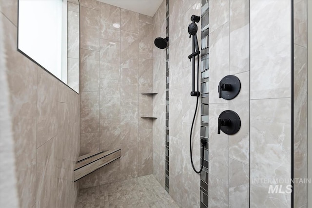 bathroom with a tile shower