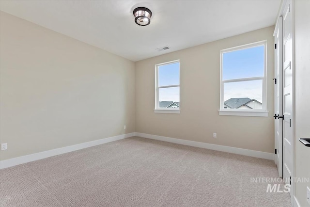 unfurnished room featuring visible vents, baseboards, and light colored carpet