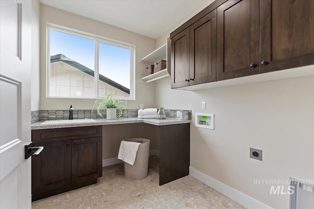 clothes washing area featuring baseboards, hookup for a washing machine, cabinet space, electric dryer hookup, and a sink