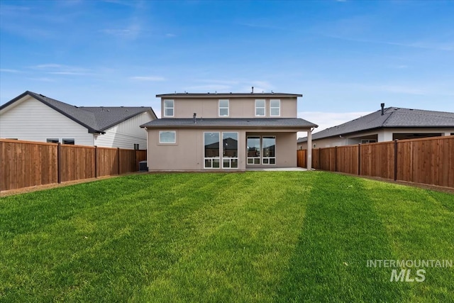 back of property with a lawn, a fenced backyard, and stucco siding