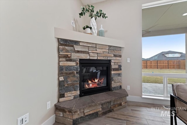 interior details featuring a fireplace, baseboards, and wood finished floors