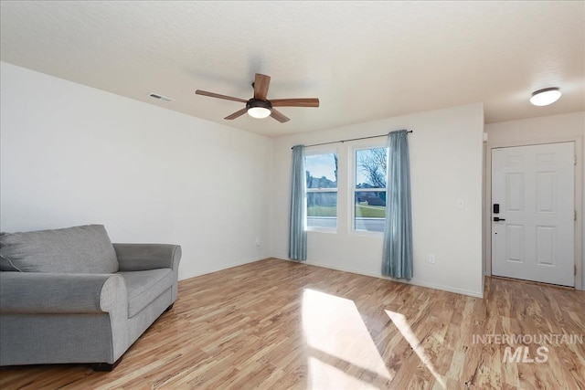 sitting room with light wood-type flooring and ceiling fan