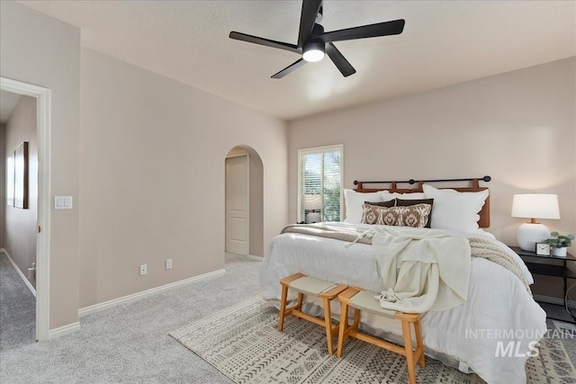 bedroom featuring ceiling fan, carpet, arched walkways, and baseboards