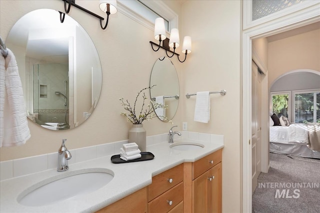 bathroom with a sink, connected bathroom, walk in shower, and double vanity