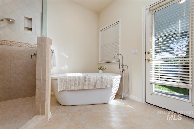 full bathroom with baseboards, a soaking tub, tile patterned flooring, and a walk in shower