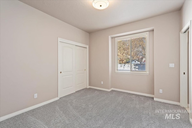 unfurnished bedroom featuring a closet, baseboards, and carpet floors