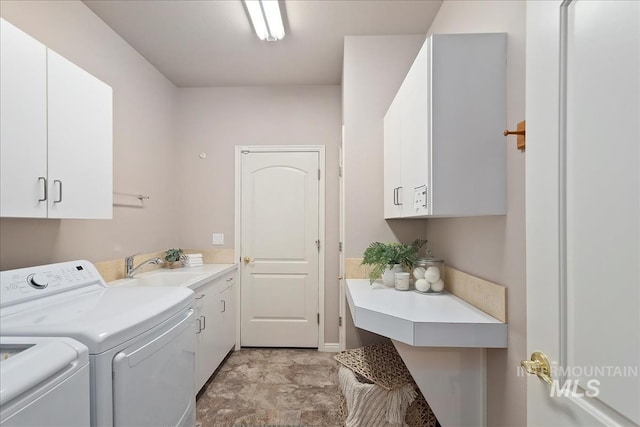 laundry area featuring cabinet space, independent washer and dryer, and a sink