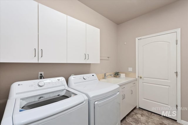 laundry room featuring separate washer and dryer, cabinet space, and a sink