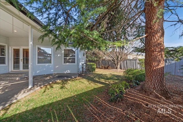 view of yard with french doors and fence