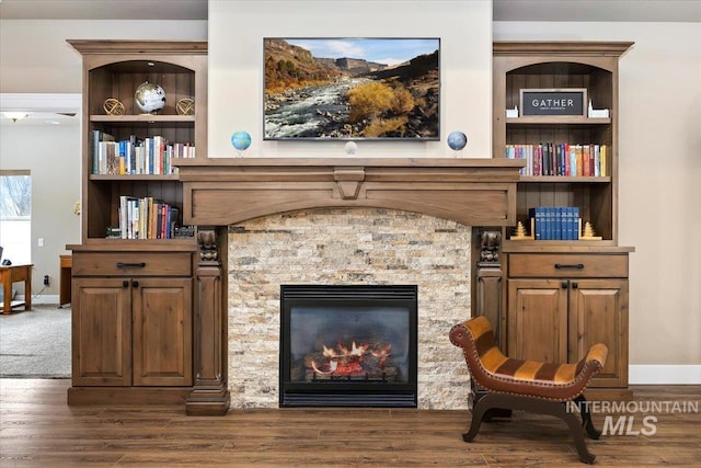 living area with dark hardwood / wood-style flooring and a fireplace