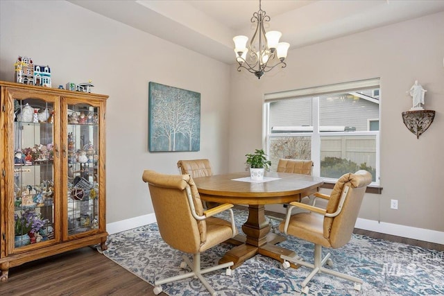 dining area featuring dark wood-type flooring and a chandelier