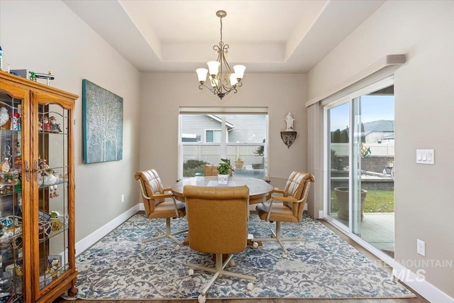 dining space featuring a tray ceiling and an inviting chandelier