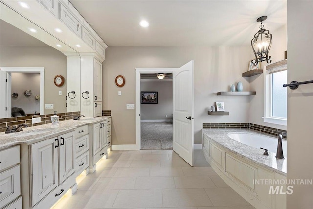 bathroom with tile patterned floors, vanity, decorative backsplash, and a bath