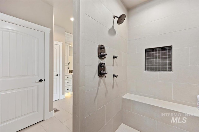 bathroom with tile patterned flooring and tiled shower