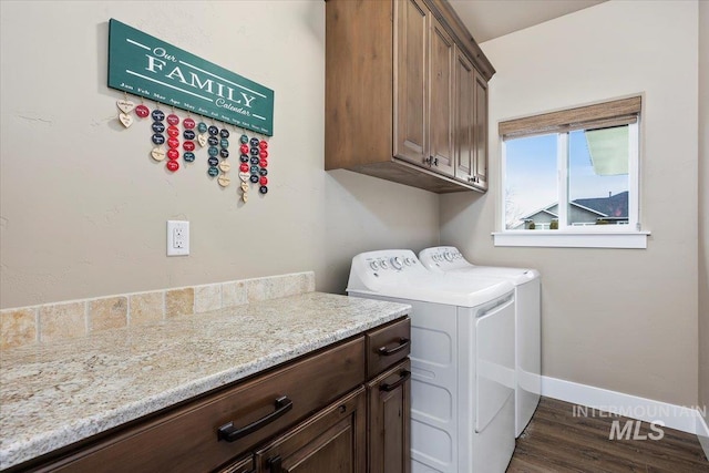 washroom featuring dark hardwood / wood-style flooring, cabinets, and separate washer and dryer