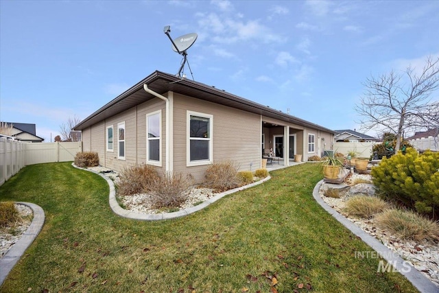 rear view of property featuring a patio and a lawn