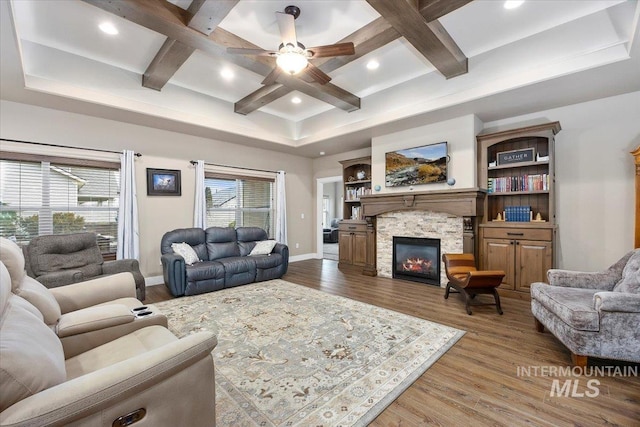 living room featuring a fireplace, hardwood / wood-style flooring, ceiling fan, and coffered ceiling