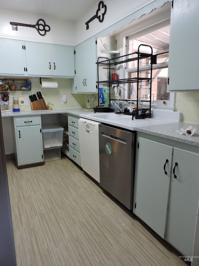 kitchen featuring light wood-type flooring, backsplash, light countertops, and dishwasher