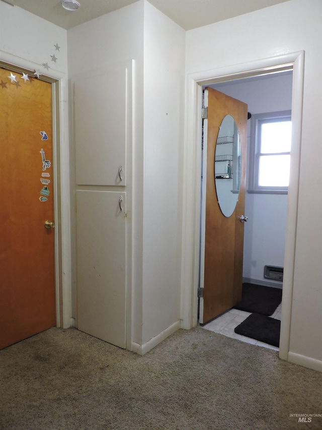 hall featuring carpet and baseboards