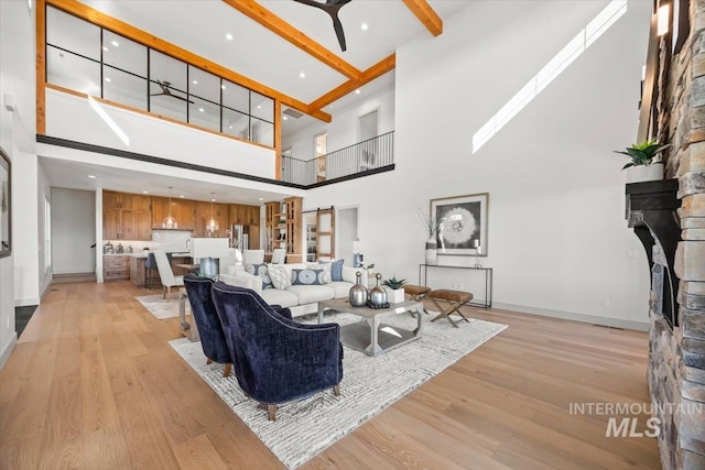 8860 Kemp Rd, Middleton, ID 83607 - living area with a towering ceiling, a ceiling fan, light wood-style floors, a fireplace, and baseboards