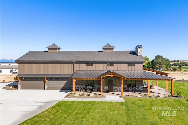 8860 Kemp Rd, Middleton, ID 83607 - view of front of home with stone siding, concrete driveway, a chimney, a front lawn, and a standing seam roof