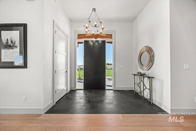 8860 Kemp Rd, Middleton, ID 83607 - foyer with baseboards, a chandelier, and dark stone finish flooring