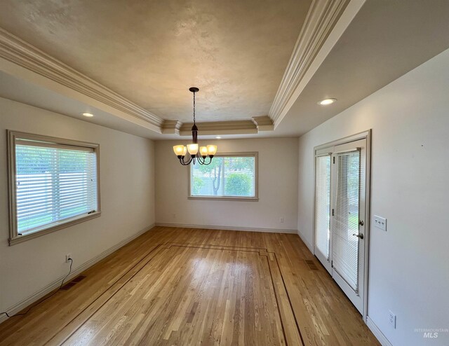 315 Shadetree Trl, Twin Falls, ID 83301 - unfurnished dining area with crown molding, a raised ceiling, light wood-style floors, a chandelier, and baseboards