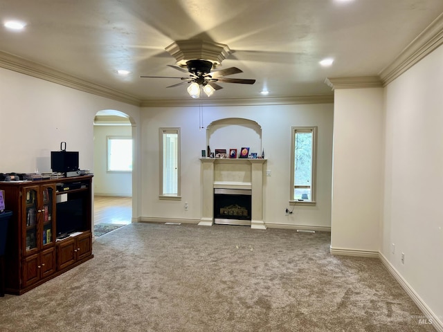 315 Shadetree Trl, Twin Falls, ID 83301 - unfurnished living room featuring ceiling fan, carpet floors, arched walkways, a fireplace, and crown molding