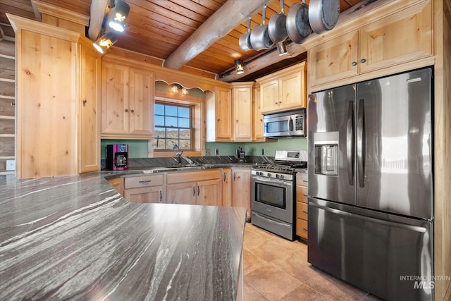 kitchen featuring light brown cabinetry, appliances with stainless steel finishes, beam ceiling, and wood ceiling