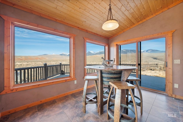 tiled dining space featuring wood ceiling, a mountain view, and lofted ceiling