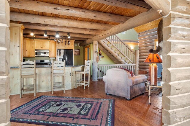 living room with dark hardwood / wood-style flooring, log walls, and beam ceiling