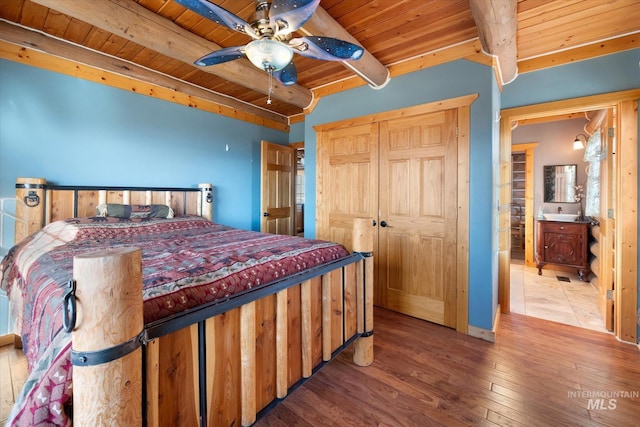 bedroom featuring ceiling fan, light hardwood / wood-style floors, beam ceiling, wooden ceiling, and connected bathroom