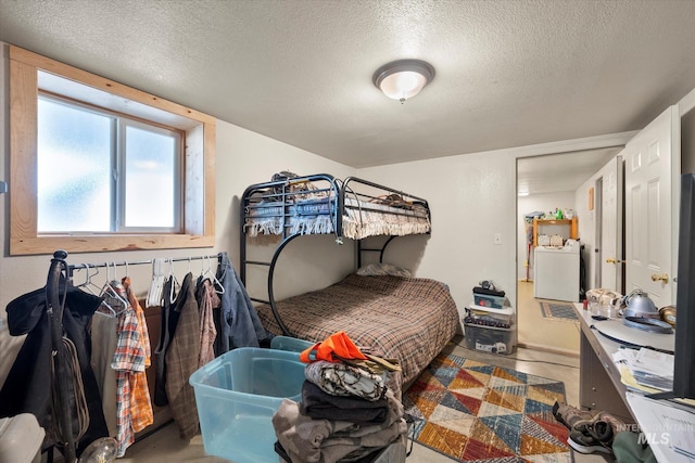 bedroom featuring washer / dryer and a textured ceiling