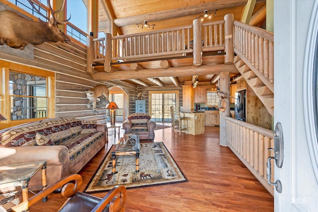 living room with high vaulted ceiling, log walls, beamed ceiling, and dark hardwood / wood-style flooring