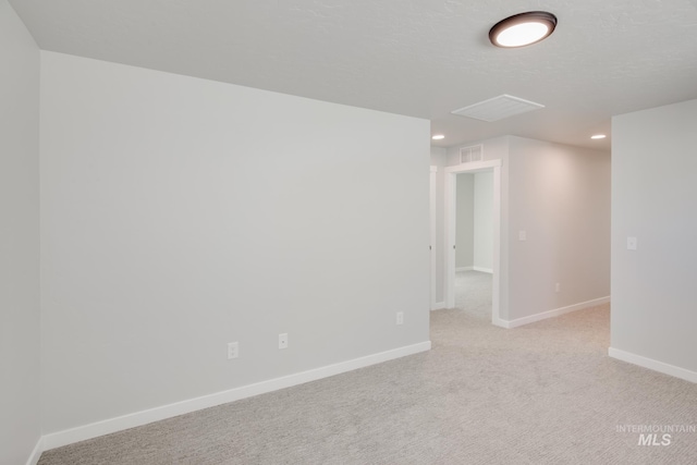 empty room with baseboards, recessed lighting, visible vents, and light colored carpet
