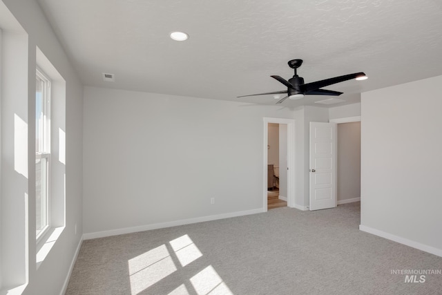 empty room with carpet floors, visible vents, baseboards, ceiling fan, and recessed lighting
