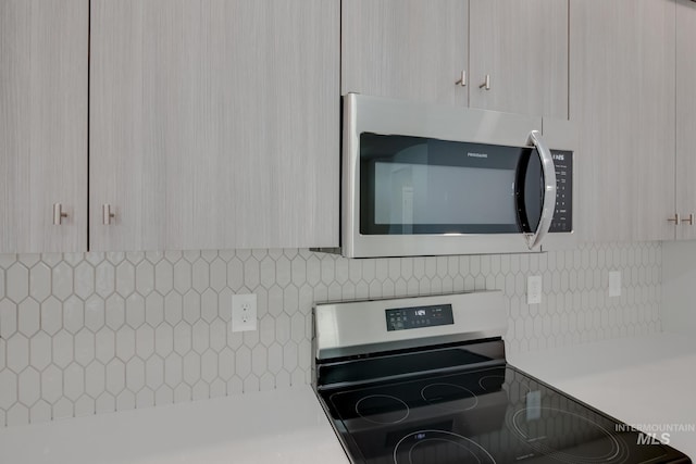 kitchen featuring light countertops, appliances with stainless steel finishes, and tasteful backsplash